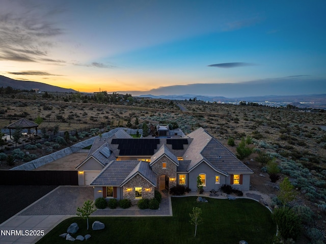 5427 Salmon River Ct, Reno, NV 89511 - view of front of property with a mountain view, a front yard, stone siding, and driveway