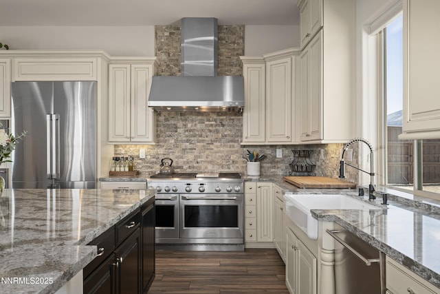 5427 Salmon River Ct, Reno, NV 89511 - kitchen with high end appliances, wall chimney exhaust hood, dark wood-type flooring, tasteful backsplash, and light stone countertops