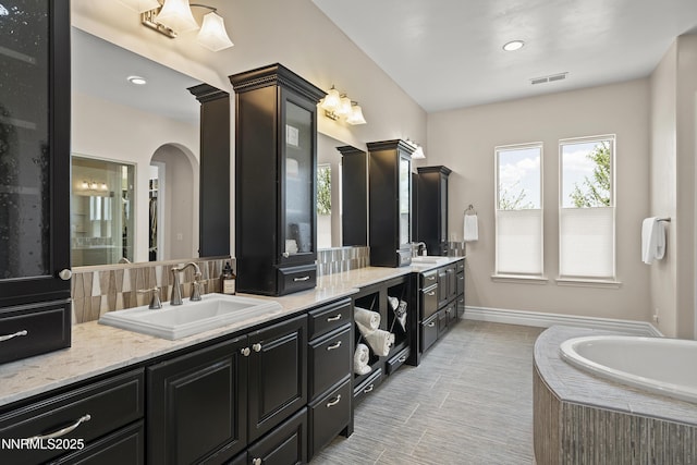 5427 Salmon River Ct, Reno, NV 89511 - full bathroom with vanity, plenty of natural light, a garden tub, recessed lighting, and tasteful backsplash