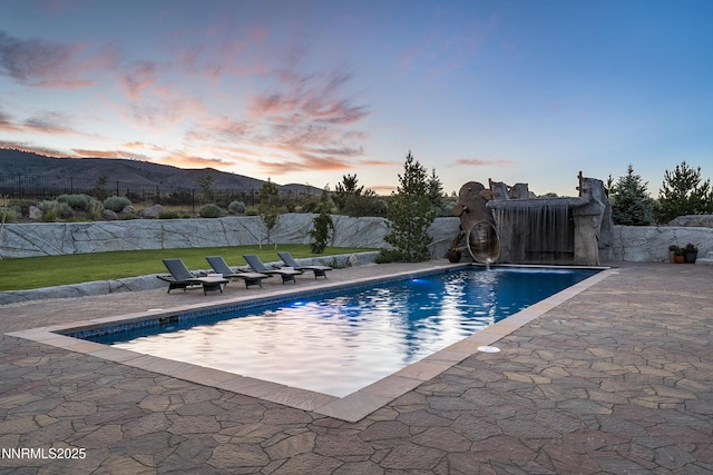 5427 Salmon River Ct, Reno, NV 89511 - pool at dusk featuring a patio area and a mountain view