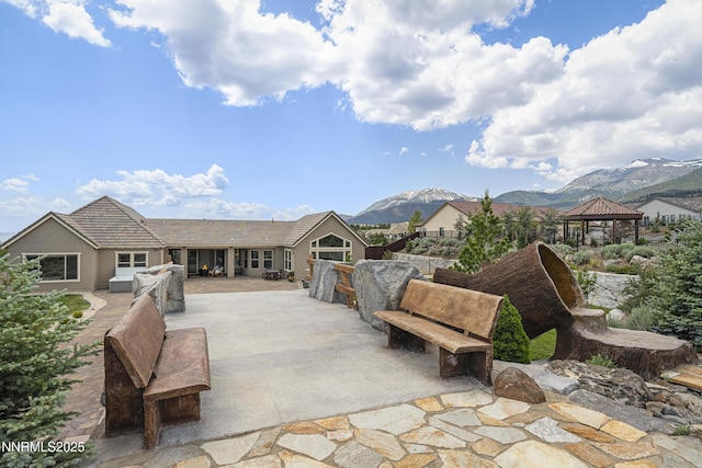 5427 Salmon River Ct, Reno, NV 89511 - view of front facade featuring a gazebo, a patio area, a mountain view, and stucco siding
