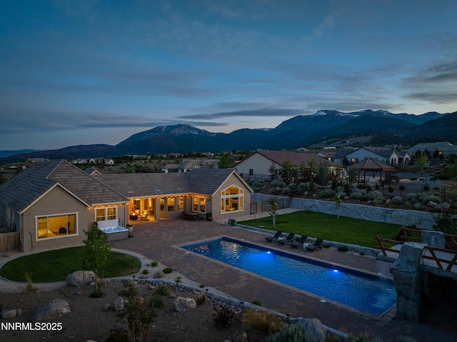 5427 Salmon River Ct, Reno, NV 89511 - pool at dusk featuring a gazebo, a mountain view, and a fenced backyard