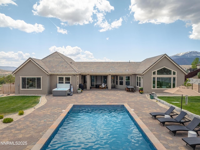5427 Salmon River Ct, Reno, NV 89511 - back of property featuring an outdoor hot tub, a patio area, stucco siding, and a mountain view