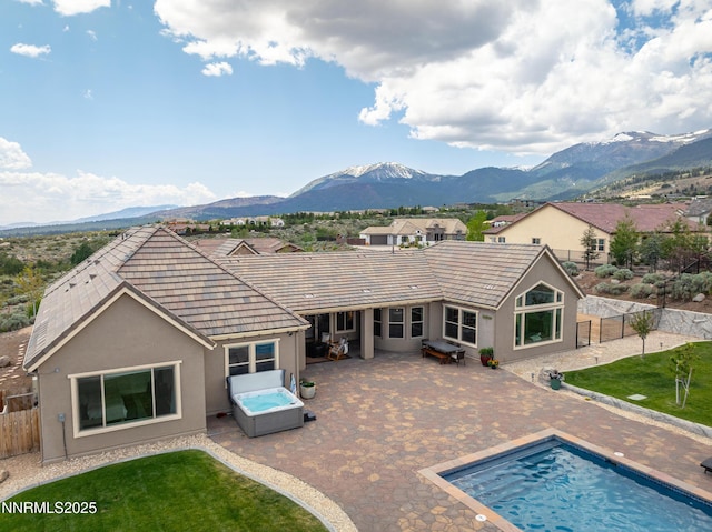 5427 Salmon River Ct, Reno, NV 89511 - rear view of house featuring a hot tub, a mountain view, a fenced backyard, and a patio area