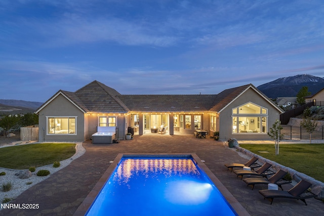 5427 Salmon River Ct, Reno, NV 89511 - rear view of property featuring a mountain view, stucco siding, a patio, and a hot tub