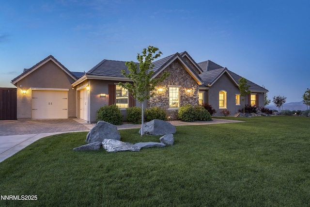 5427 Salmon River Ct, Reno, NV 89511 - view of front of home with stone siding, decorative driveway, an attached garage, and a front lawn