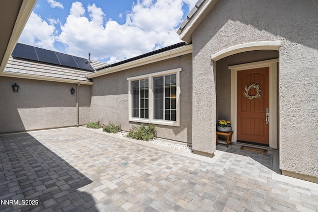 5427 Salmon River Ct, Reno, NV 89511 - entrance to property with stucco siding, roof mounted solar panels, and a patio area