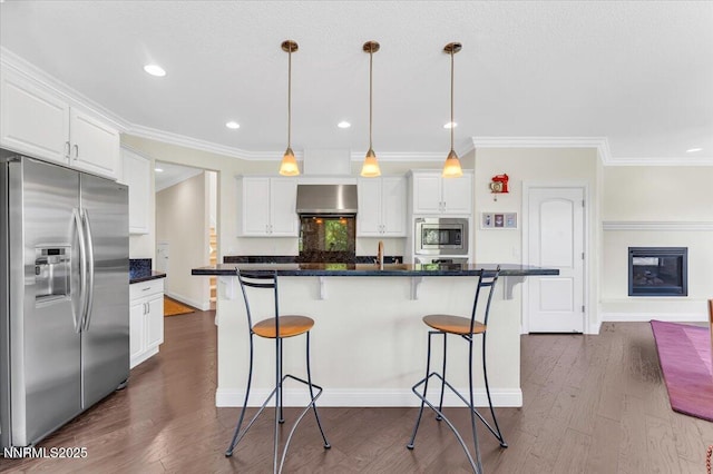 1636 Robb Dr, Carson City, NV 89703 - kitchen featuring appliances with stainless steel finishes, white cabinetry, wall chimney range hood, a kitchen bar, and crown molding