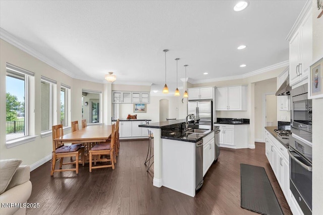 1636 Robb Dr, Carson City, NV 89703 - kitchen featuring appliances with stainless steel finishes, dark countertops, dark wood-style floors, white cabinetry, and ornamental molding
