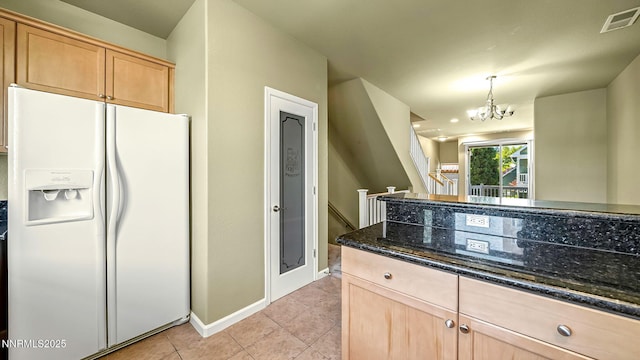 225 Gramercy Ln, Reno, NV 89509 - kitchen with white fridge with ice dispenser, light brown cabinets, dark stone counters, and light tile patterned floors