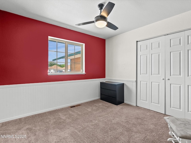 431 Michael Dr, Fallon, NV 89406 - unfurnished bedroom featuring a wainscoted wall, a closet, carpet, and ceiling fan