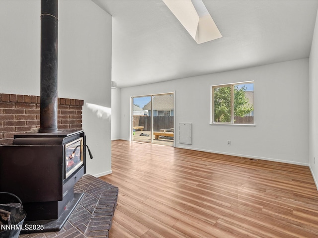 431 Michael Dr, Fallon, NV 89406 - unfurnished living room with a wood stove, a skylight, plenty of natural light, and wood finished floors
