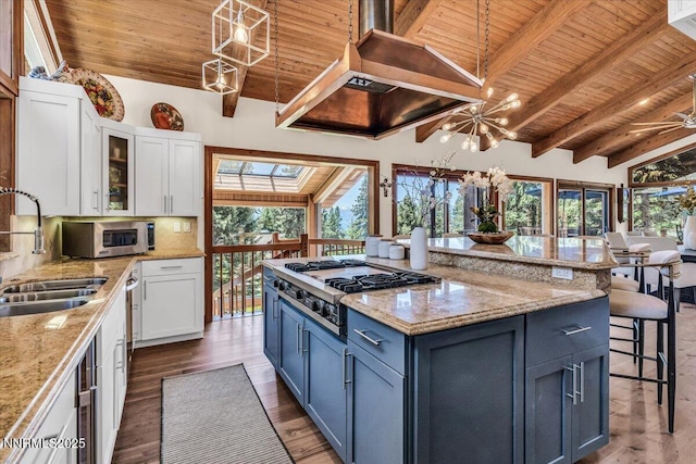 1263 Hidden Woods Dr, Zephyr Cove, NV 89413 - kitchen with wooden ceiling, stainless steel appliances, white cabinets, a kitchen bar, and wood finished floors
