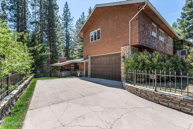1263 Hidden Woods Dr, Zephyr Cove, NV 89413 - view of side of home with stone siding, concrete driveway, and an attached garage