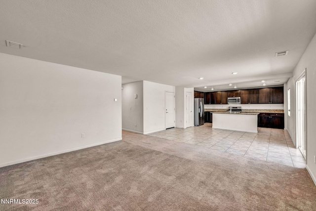 8977 Sagemoor Dr, Reno, NV 89506 - unfurnished living room featuring light colored carpet, a textured ceiling, light tile patterned floors, and recessed lighting