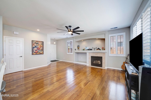 1575 Canyonlands Ct, Reno, NV 89521 - unfurnished living room with a tile fireplace, a ceiling fan, light wood-type flooring, plenty of natural light, and recessed lighting