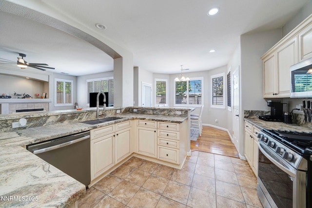 1575 Canyonlands Ct, Reno, NV 89521 - kitchen featuring stainless steel appliances, cream cabinetry, ceiling fan, recessed lighting, and light stone counters