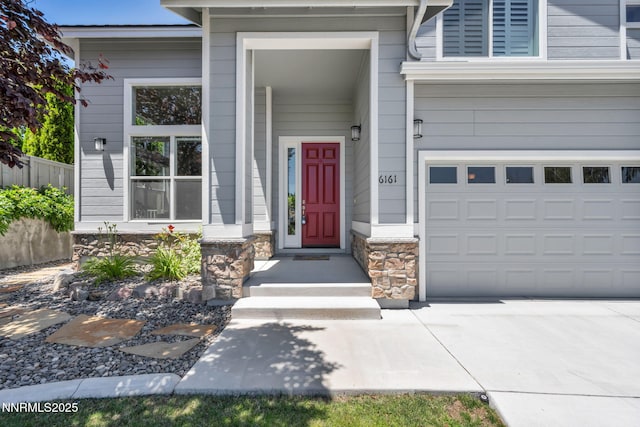 6161 Wycliffe Cir, Reno, NV 89519 - entrance to property with stone siding, an attached garage, and driveway