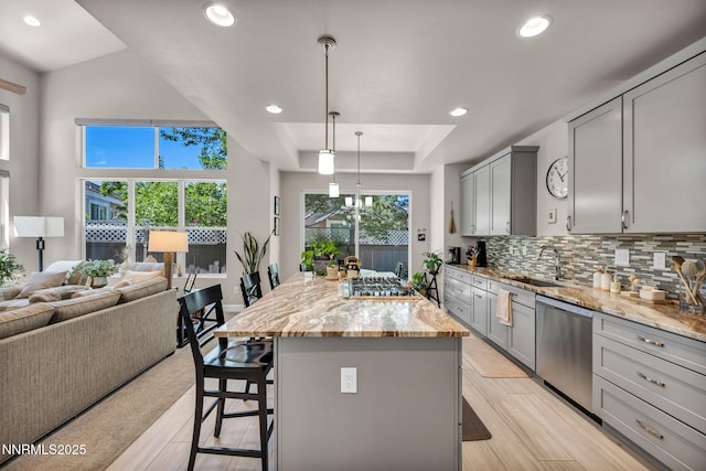 6161 Wycliffe Cir, Reno, NV 89519 - kitchen featuring stainless steel appliances, gray cabinetry, a kitchen bar, open floor plan, and light stone countertops
