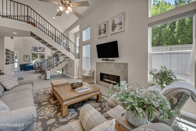 6161 Wycliffe Cir, Reno, NV 89519 - carpeted living area with a towering ceiling, ceiling fan, a tile fireplace, stairway, and recessed lighting