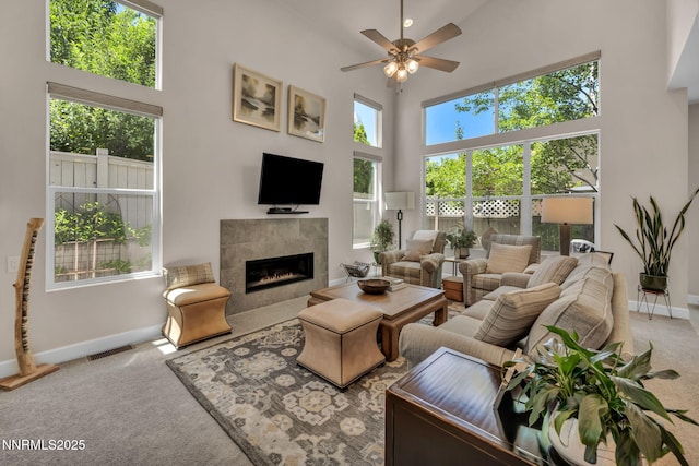 6161 Wycliffe Cir, Reno, NV 89519 - carpeted living area with a tiled fireplace, a ceiling fan, and a towering ceiling