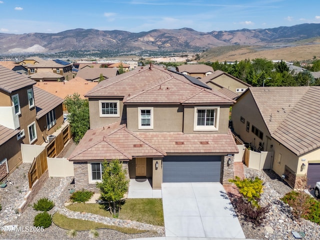 14144 American Pillar Ct, Reno, NV 89511 - traditional home featuring stucco siding, concrete driveway, a tiled roof, an attached garage, and a mountain view