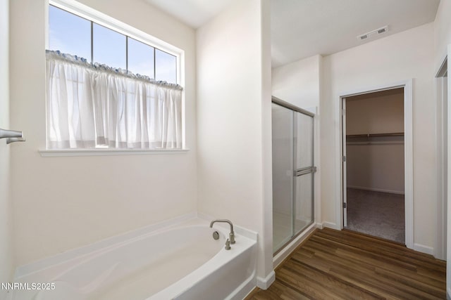 14144 American Pillar Ct, Reno, NV 89511 - full bathroom featuring a shower stall, a bath, a spacious closet, and wood finished floors
