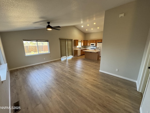 8 Conner Way, Gardnerville, NV 89410 - unfurnished living room with vaulted ceiling, a ceiling fan, and wood finished floors