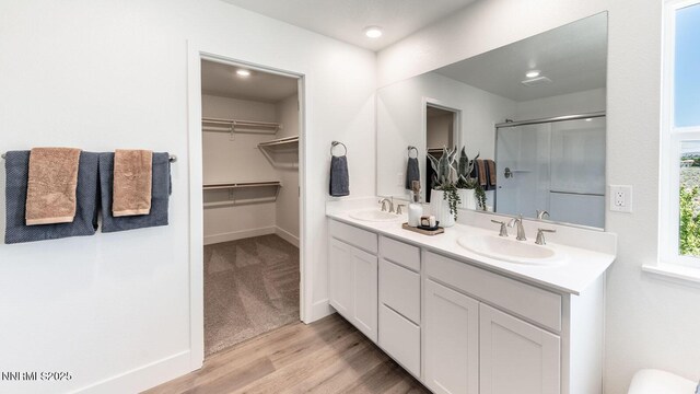 7602 Apex Pl # 106, Reno, NV 89506 - full bathroom featuring a stall shower, double vanity, wood finished floors, and a walk in closet