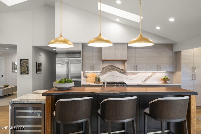 10594 Dixon Ln, Reno, NV 89511 - kitchen featuring beverage cooler, built in fridge, high vaulted ceiling, a skylight, and wood finished floors