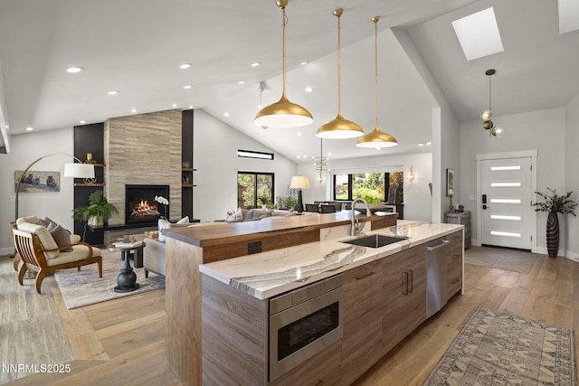 10594 Dixon Ln, Reno, NV 89511 - kitchen with modern cabinets, a tiled fireplace, a spacious island, open floor plan, and appliances with stainless steel finishes