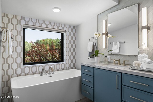 10594 Dixon Ln, Reno, NV 89511 - bathroom featuring wallpapered walls, a freestanding tub, vanity, and backsplash