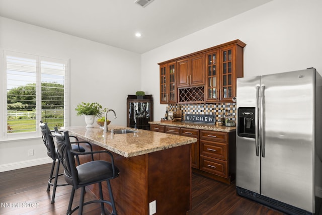 10594 Dixon Ln, Reno, NV 89511 - kitchen with stainless steel fridge with ice dispenser, dark wood finished floors, tasteful backsplash, light stone counters, and recessed lighting