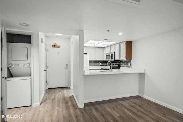 3095 Lakeside Unit 203, Reno, NV 89509 - kitchen featuring stainless steel microwave, stacked washer and clothes dryer, freestanding refrigerator, wood finished floors, and recessed lighting