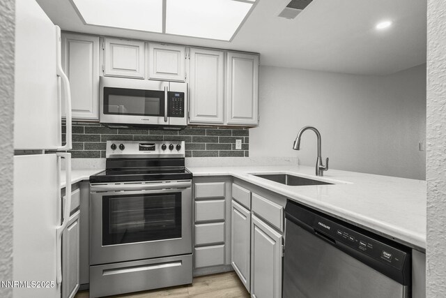 3095 Lakeside Unit 203, Reno, NV 89509 - kitchen with stainless steel appliances, light countertops, backsplash, and light wood-type flooring