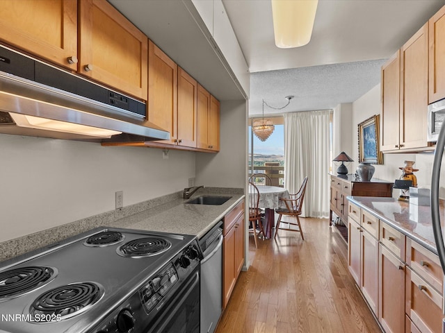 100 N Arlington Ave Unit 20J, Reno, NV 89501 - kitchen featuring appliances with stainless steel finishes, extractor fan, light wood-style floors, and light stone counters