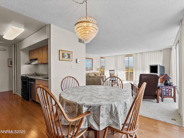 100 N Arlington Ave Unit 20J, Reno, NV 89501 - dining space featuring a textured ceiling, a chandelier, and light wood-style flooring