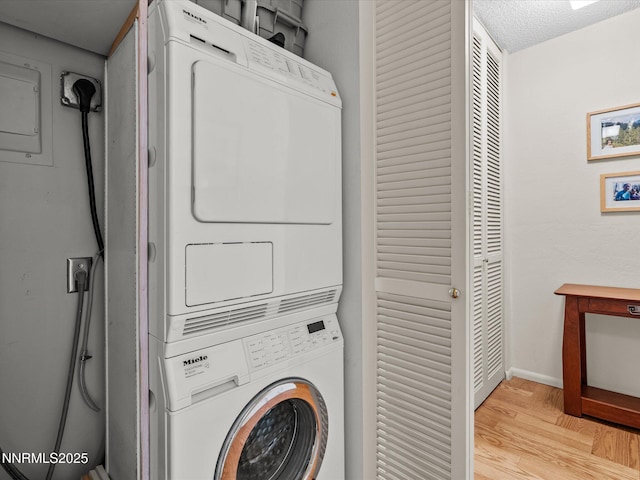 100 N Arlington Ave Unit 20J, Reno, NV 89501 - laundry room featuring stacked washer and clothes dryer and light wood-type flooring