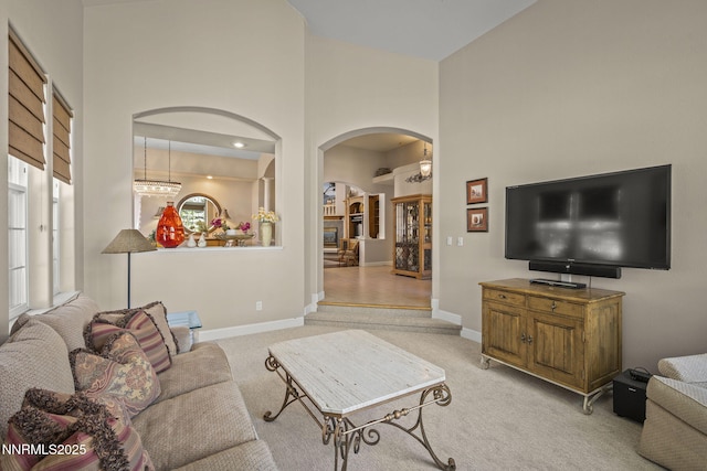 4374 Cullen Ct, Reno, NV 89519 - living room featuring arched walkways, a towering ceiling, and light colored carpet