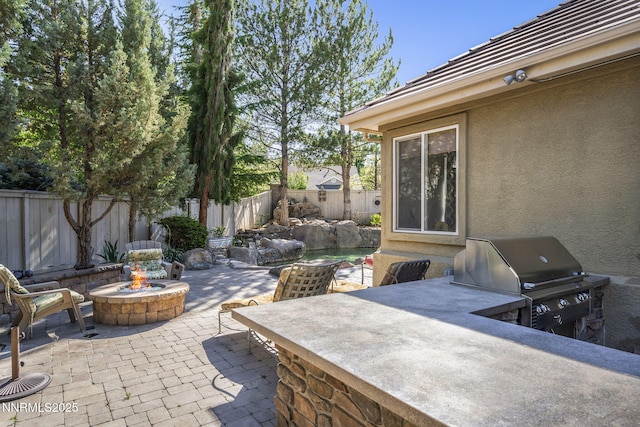 4374 Cullen Ct, Reno, NV 89519 - fenced backyard with an outdoor fire pit, a patio area, and exterior kitchen