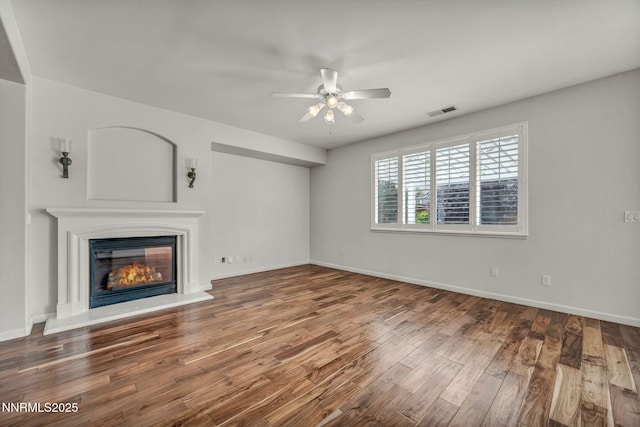 6469 Hale Bopp Ct, Sparks, NV 89436 - unfurnished living room featuring a ceiling fan, a glass covered fireplace, and wood finished floors