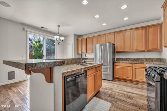 6469 Hale Bopp Ct, Sparks, NV 89436 - kitchen featuring appliances with stainless steel finishes, recessed lighting, light wood-style floors, a kitchen island with sink, and hanging light fixtures