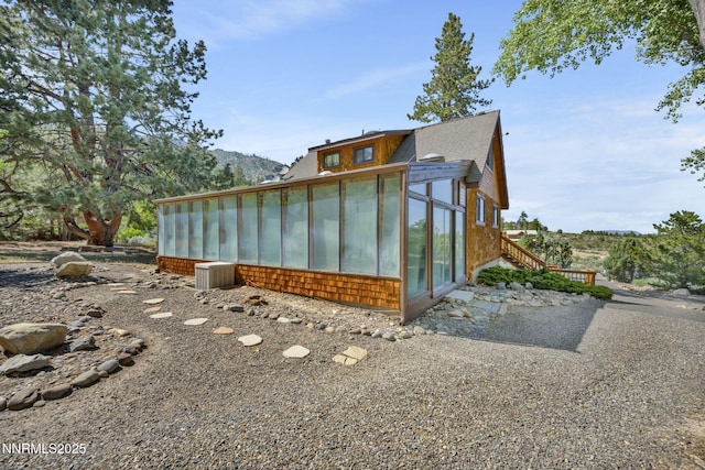 187 Jeannie Ln, Gardnerville, NV 89460 - view of side of home with a sunroom, roof with shingles, and stairs