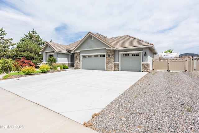 113 Denio Dr, Dayton, NV 89403 - view of front of property with a gate, an attached garage, concrete driveway, stone siding, and a tile roof