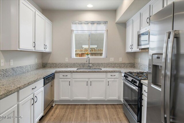 2170 Santona Cir, Reno, NV 89523 - kitchen featuring appliances with stainless steel finishes, white cabinets, light wood-style flooring, light stone countertops, and recessed lighting
