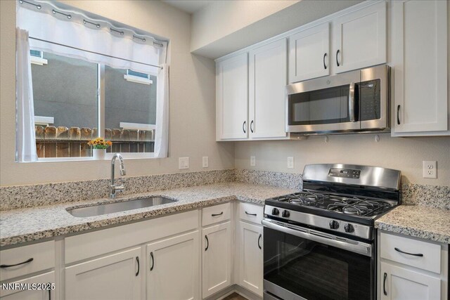 2170 Santona Cir, Reno, NV 89523 - kitchen featuring appliances with stainless steel finishes, white cabinetry, and light stone counters