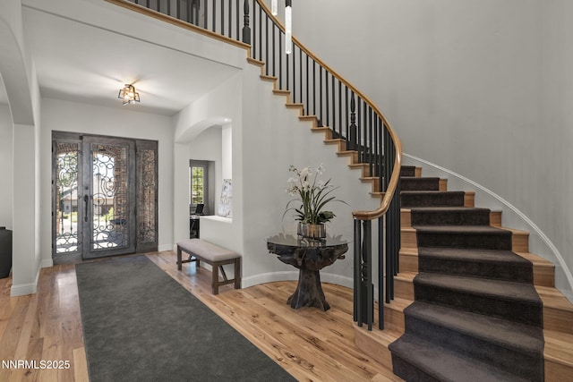 5830 Strasbourg Ct, Reno, NV 89511 - entrance foyer featuring arched walkways, stairway, wood finished floors, and a high ceiling