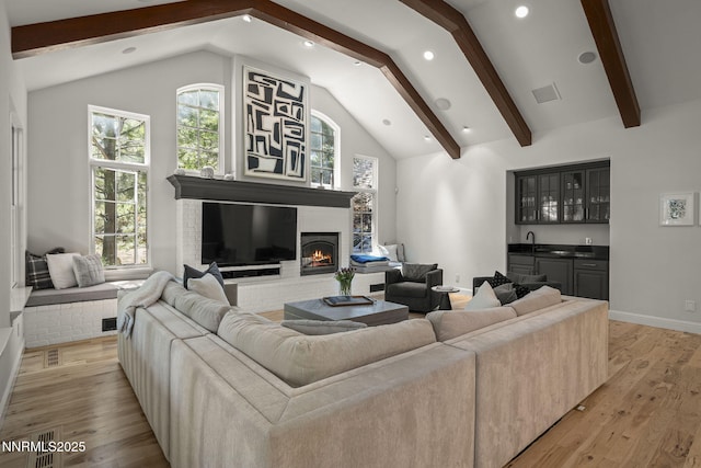 5830 Strasbourg Ct, Reno, NV 89511 - living room featuring a brick fireplace, light wood-style flooring, wet bar, and recessed lighting