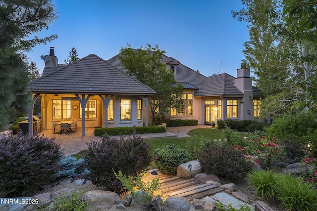 5830 Strasbourg Ct, Reno, NV 89511 - back of house featuring a chimney, stucco siding, a patio, and a lawn