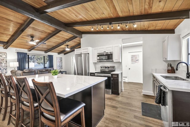 3430 Gwynelle Ct, Sparks, NV 89431 - kitchen featuring appliances with stainless steel finishes, ceiling fan, wooden ceiling, light stone counters, and light wood finished floors